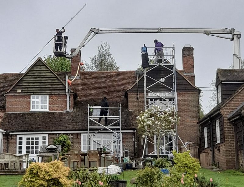 The Moss Cleaners using cherry picker and scaffolding to clean roof safely and professionally in Henfield, West Sussex